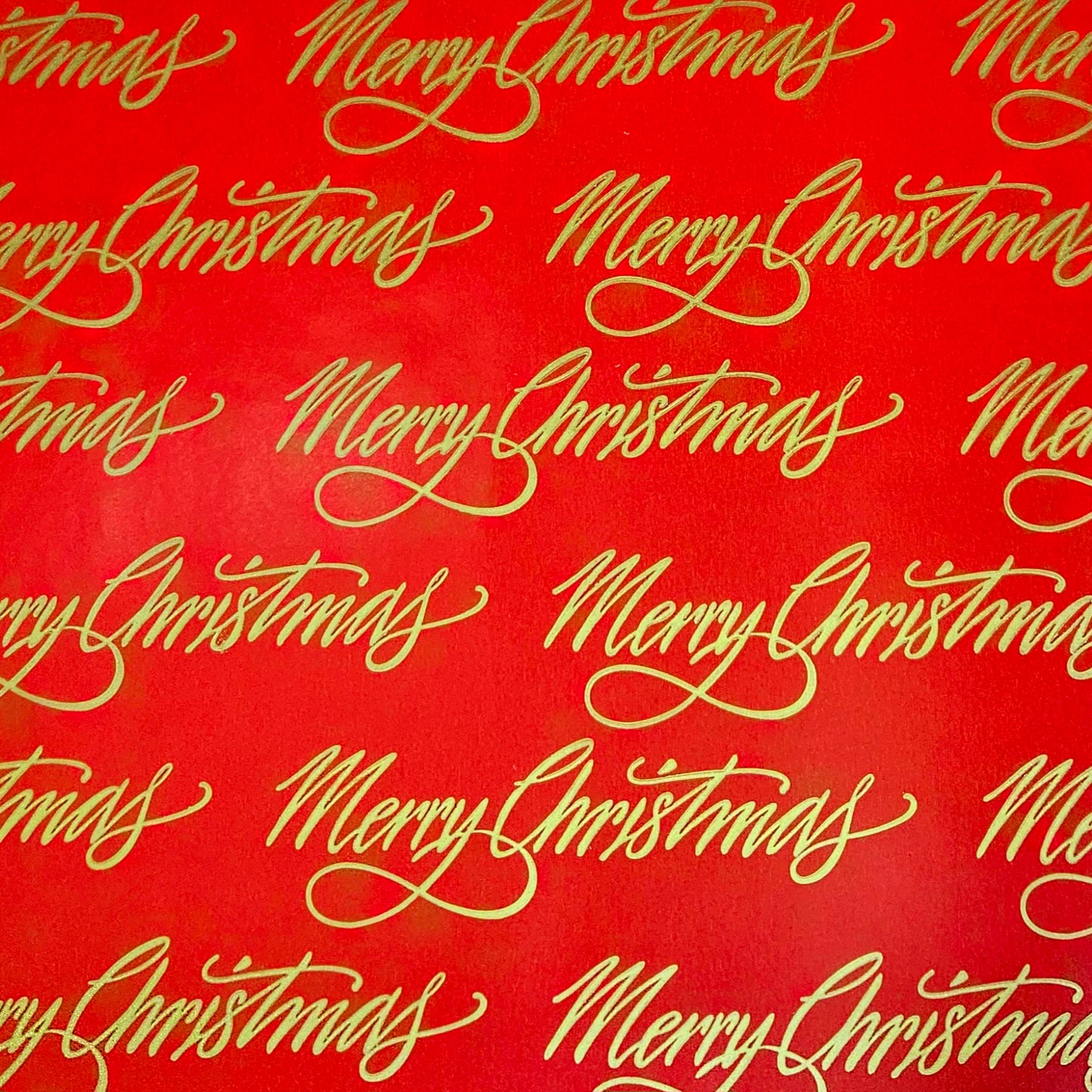 Red wrapping paper with Merry Christmas in gold print.