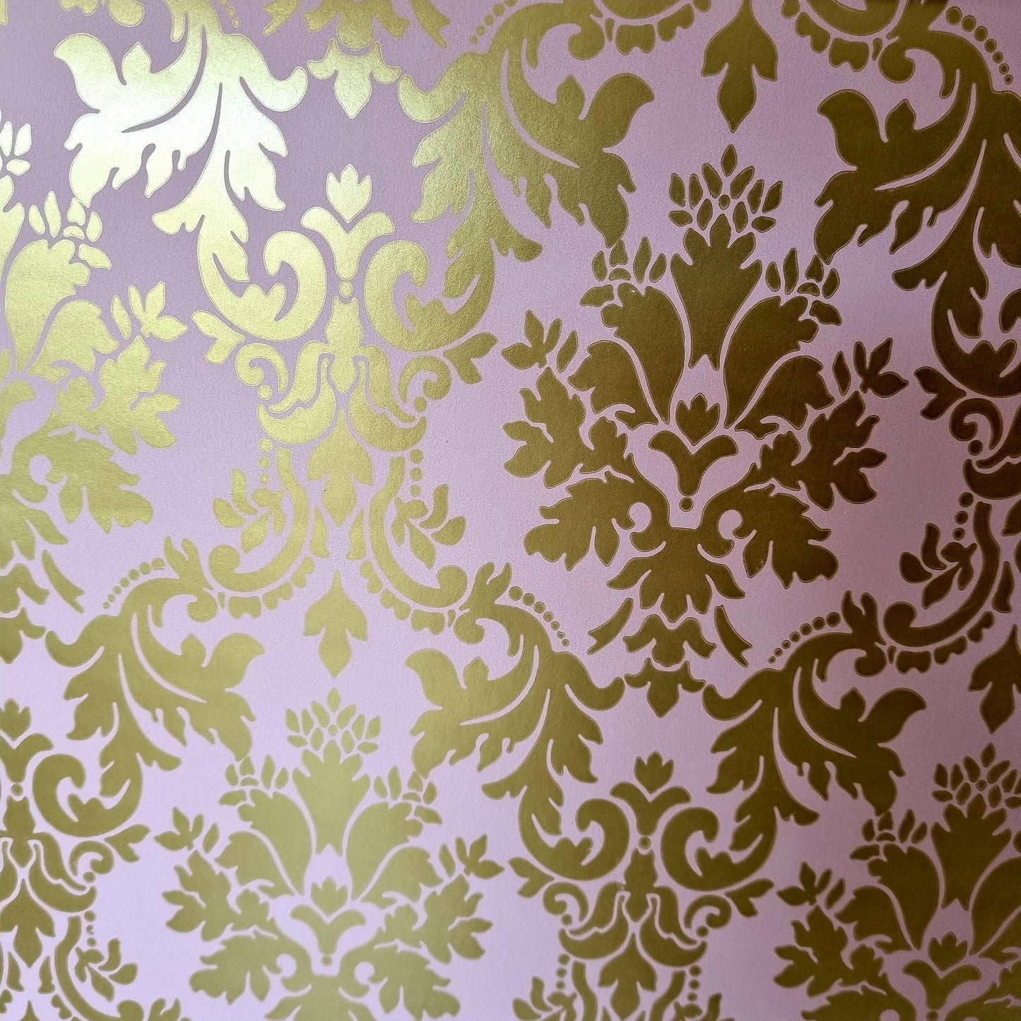 A close-up of metallic gold damask pattern wrapping paper.