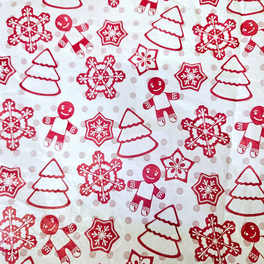 Tissue paper with a Christmas theme, featuring red snowflakes, gingerbread men, and Christmas trees.
