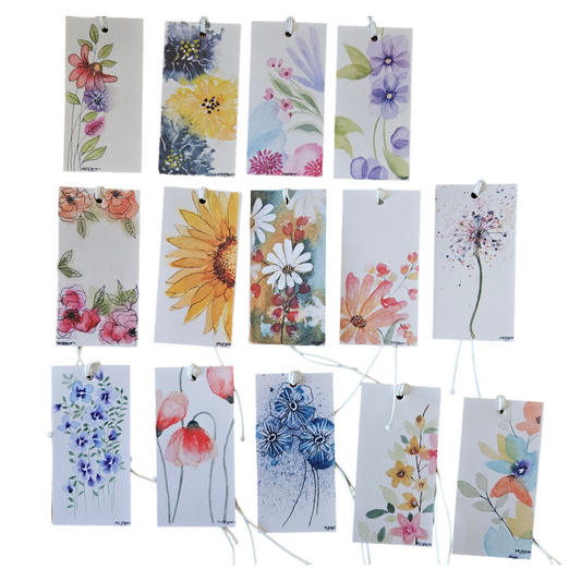 A collection of 14 hand-painted and then printed gift tags with floral designs, each featuring a different floral image, strung on white cord.