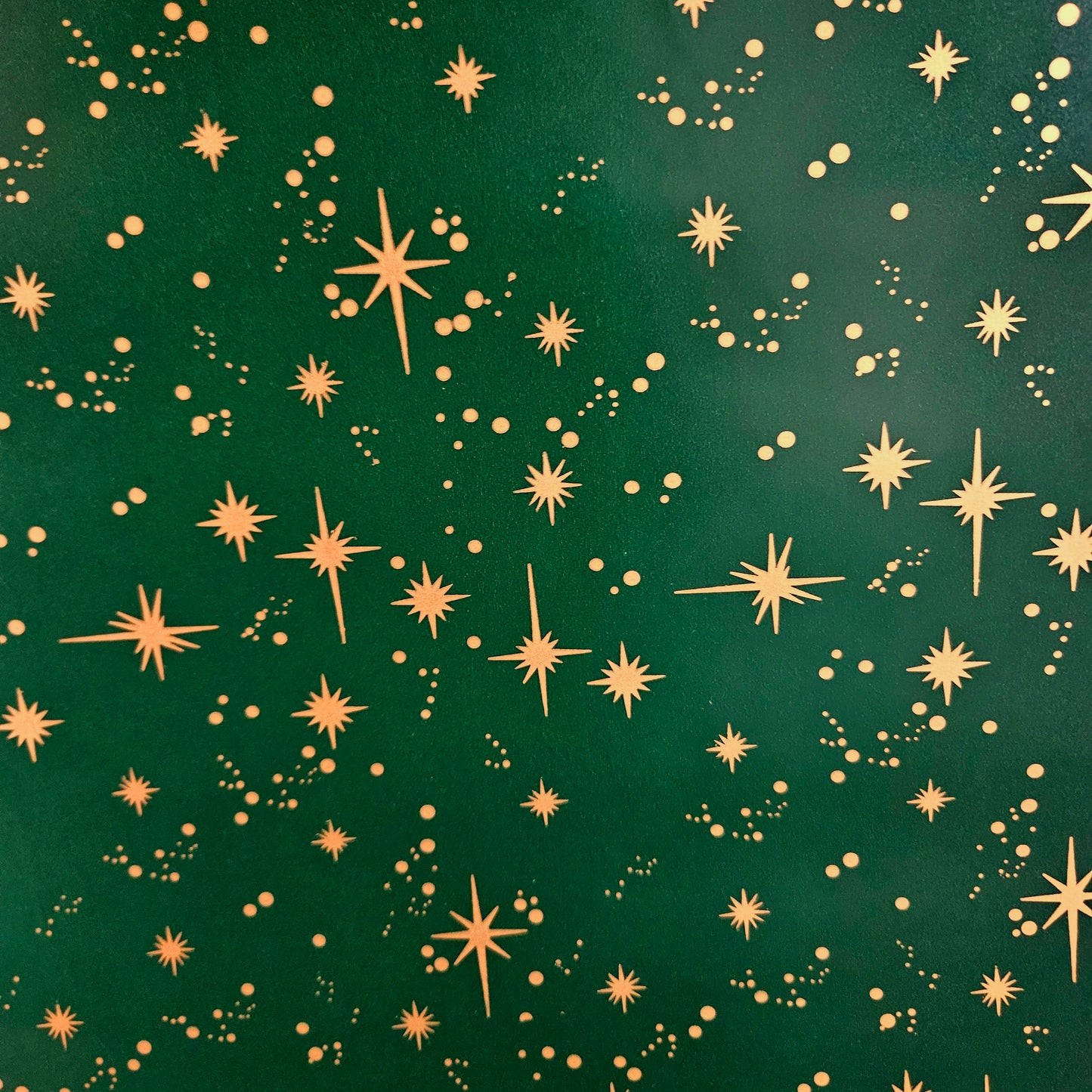 Christmas wrapping paper. Green with gold stars.