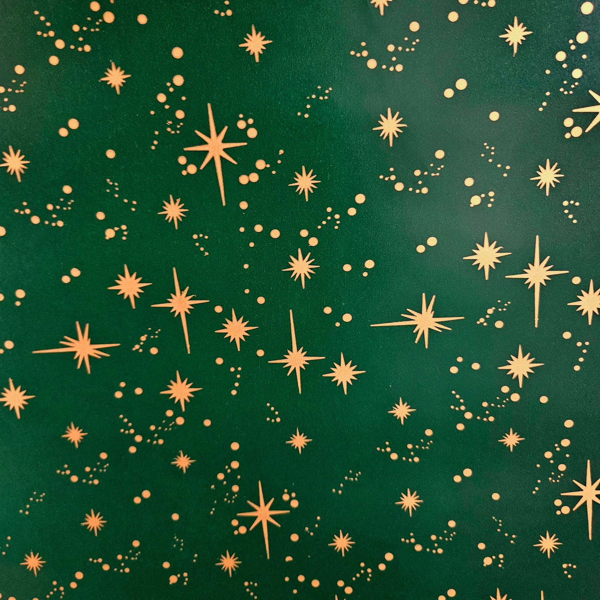 Christmas wrapping paper. Green with gold stars.