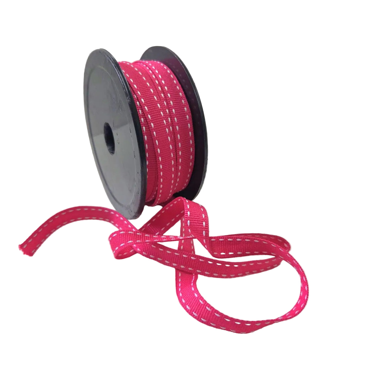 A spool of bright pink grosgrain ribbon with white dashed stitching, with a loose tail of the ribbon draped in front on a white surface.