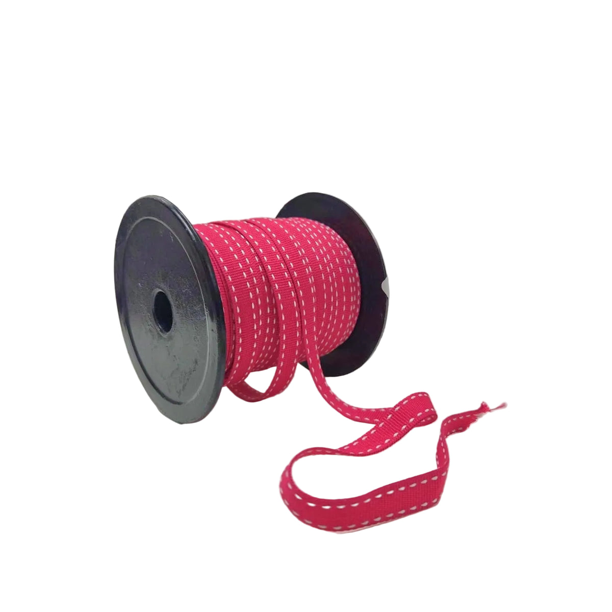 A spool of bright pink ribbon with white dashed stitching, resting on a white surface against a light gray background.