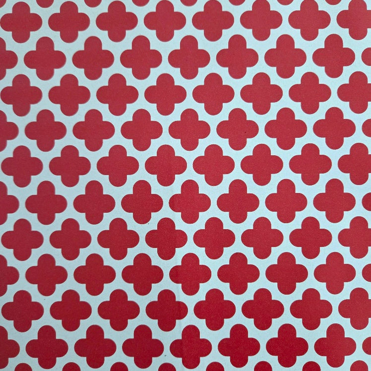Red geometric clover patterned material swatch on a white background.