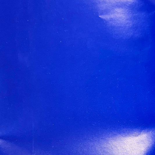 A close-up of a solid royal blue wrapping paper with a glossy finish.