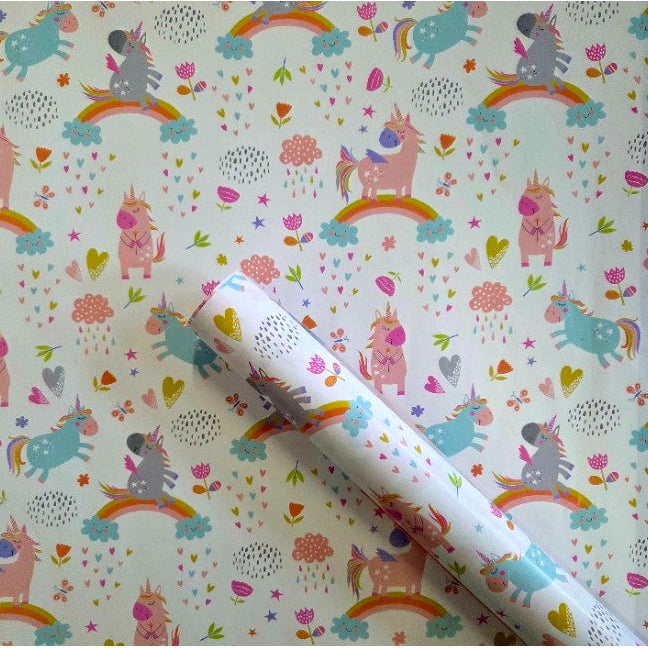 Unicorn-themed wrapping paper with a roll of paper on a white background