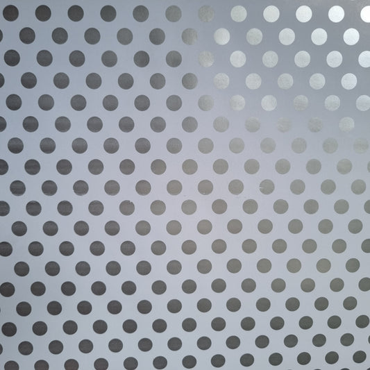 A close-up view of white wrapping paper with metallic silver polka dots.