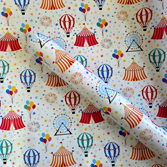 Circus-themed wrapping paper with colourful tents, balloons, and hot air balloons on a white background.