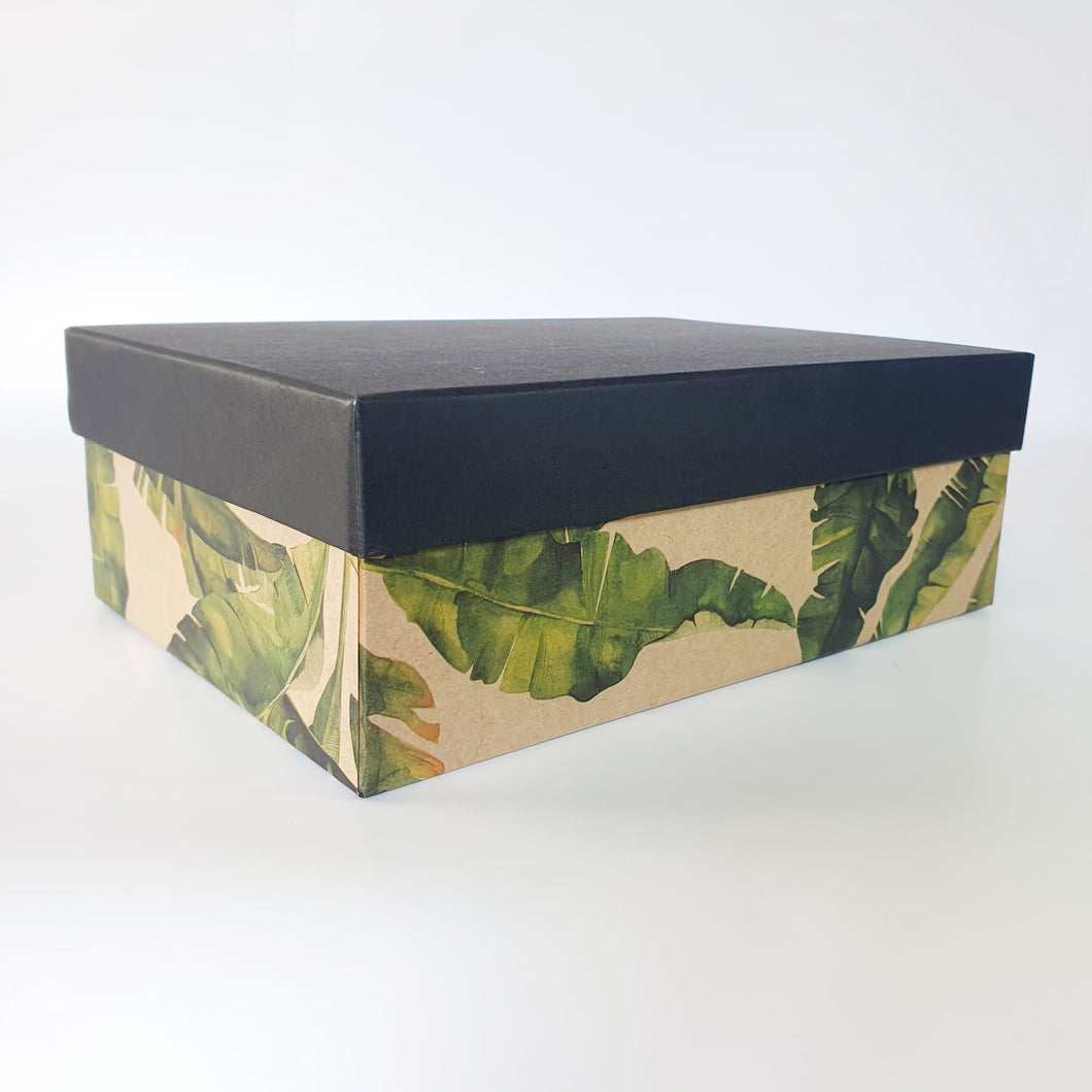 Rigid gift box.  tropical leaves on base with plain black lid.