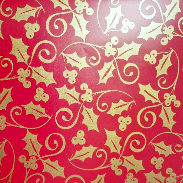 Red Christmas wrapping paper with gold holly patterns.