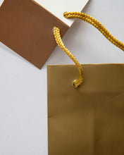 Load image into Gallery viewer, Gold Bottle Bag Close up of Cord handle and Tag
